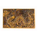 A 20thC Chinese rectangular soapstone plaque, with carved relief of a celestial dragon, flames and