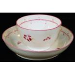 An early 19thC tea bowl and saucer, probably Minton, decorated with pink flowers with an outer