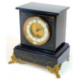 A late Victorian black slate mantel clock, with square case on shaped feet, containing a 10cm Dia. A