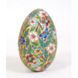 A decorative cloisonne egg, with raised floral pattern predominately in turquoise, cream, yellow and