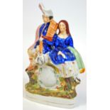 A 19thC Staffordshire pottery clock group, set with male and female, polychrome decorated on natural