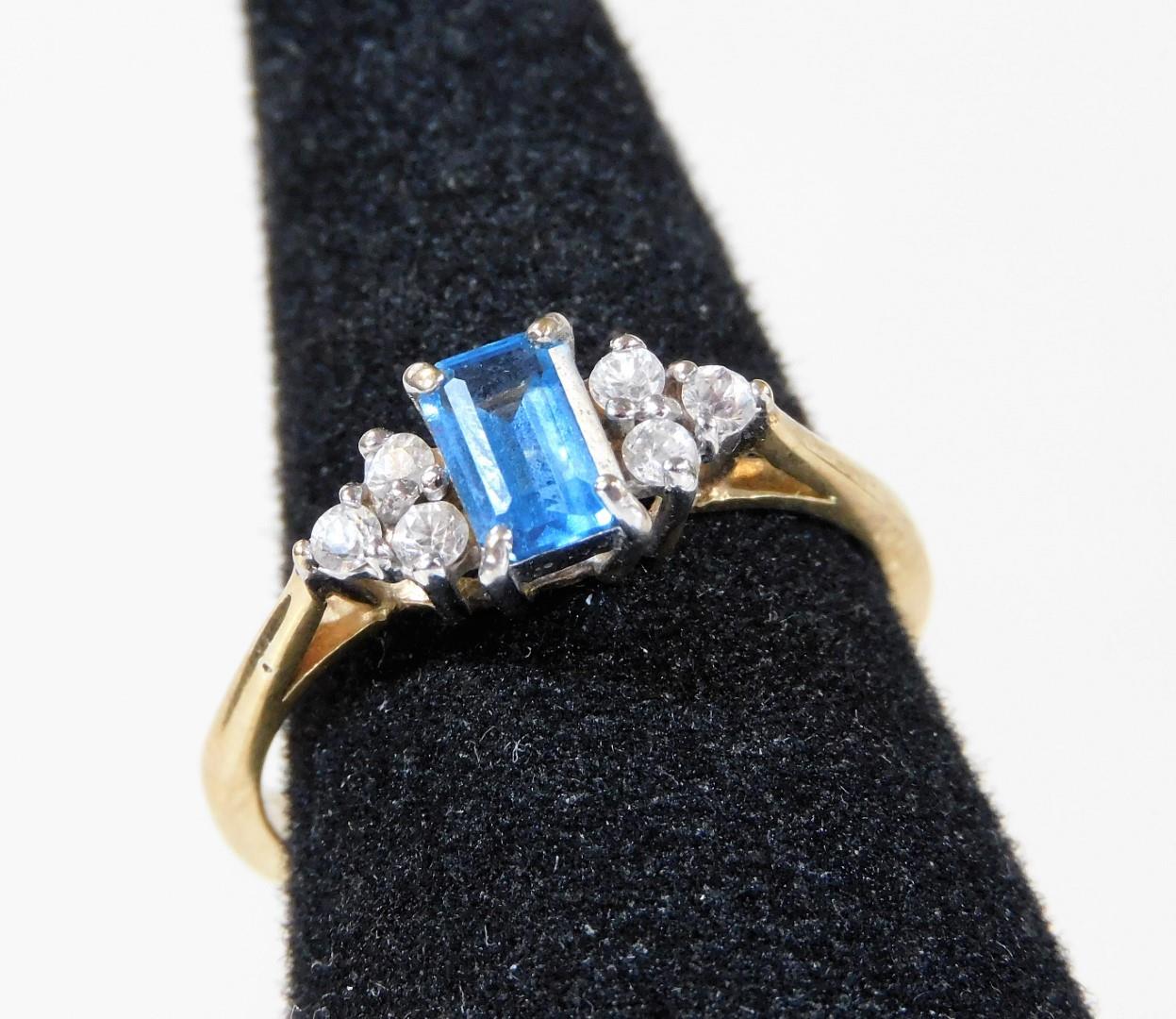 A 9ct gold dress ring, with central rectangular cut blue topaz stone, flanked by three white stones