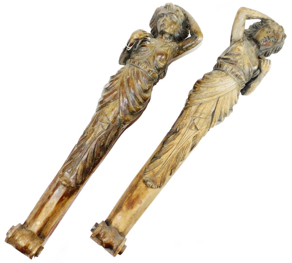 A matched pair of oak figure head style carvings, each of maidens in flowing robes, on scroll plinth