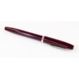 A Sheaffer fountain pen, in burgundy with banding and shaped clip, and partially enclosed nib, 14cm