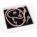 A Pandora leather charm bracelet and four charms, comprising London bus, London heart, candy cane dr