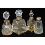 Various cut glass bottles, with silver stoppers, to include a tapering square example with orb stopp