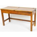 An early 20thC oak school desk, set with two lids, on block legs, joined by plain stretchers, 60cm H