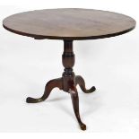 An early 19thC tilt top supper table, the circular top on a gun barrel stem terminating in triple ca