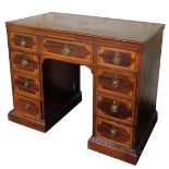 An early 19thC mahogany kneehole desk, the rounded top inlaid with a shell spandrel and oval floral