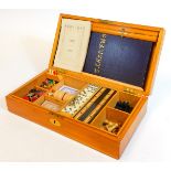 A late 19th/early 20thC games compendium, in a pine case containing dominoes, a cribbage board, ches