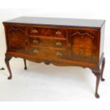 An early 20thC walnut sideboard, with three drawers flanked by panelled cupboards, with front cabrio