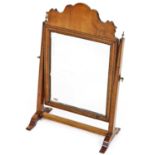 A 19thC mahogany table mirror, with carved top raised above a plain rectangular glass flanked by sq