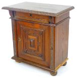 A late 19thC continental oak cabinet, the top with a heavily carved leaf border, raised above a pane