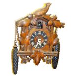 A 20thC Black Forest cuckoo clock, with shaped carved case, 9cm Dia Roman numeric dial and articulat