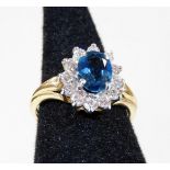 A 9ct gold cluster ring, with central blue topaz surrounded by white stones, in claw setting, ring s