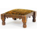 An early 20thC mahogany stained footstool, with overstuffed studded seat in geometric floral pattern