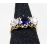 A 9ct gold three stone dress ring, with central bluey/purple stone flanked by two white stones, each