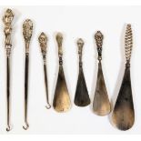 Various silver handled implements, button hooks, shoe horns, 23cm W, etc. some with silver handles.