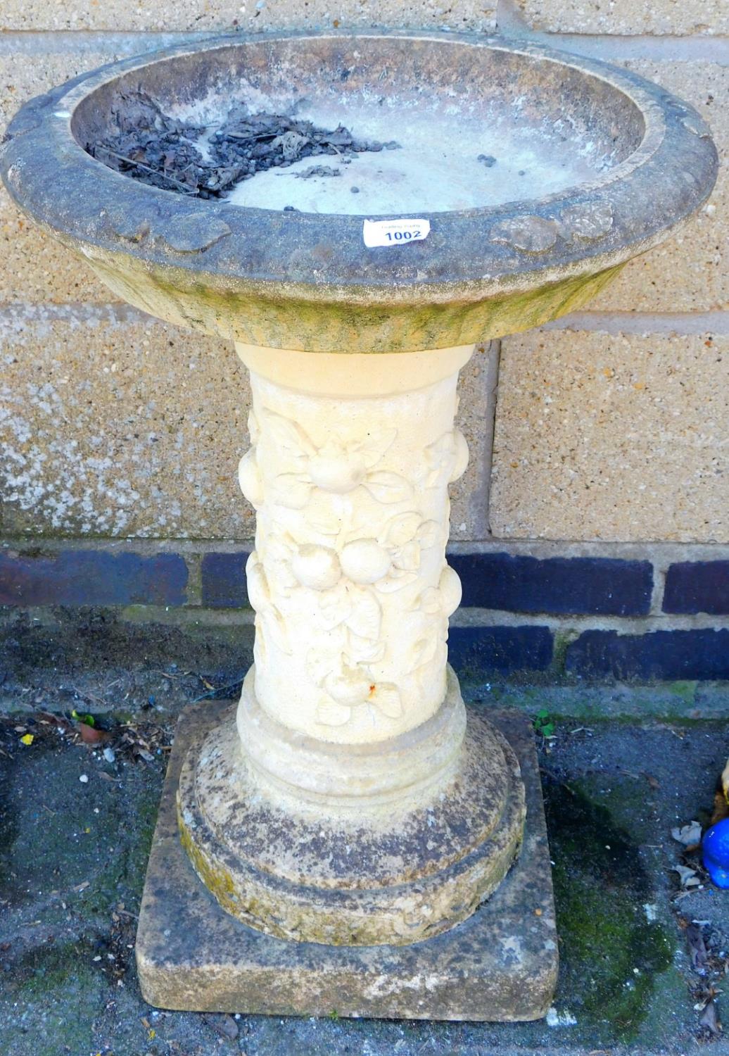 A reconstituted stone bird bath.