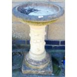 A reconstituted stone bird bath.