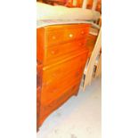 An unusual chest of five drawers with cup handles and a rug.