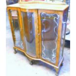 A 1960's walnut display cabinet, with two glazed doors decorated with a silver coloured border, on c