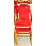 A set of six conference chairs, with overstuffed back and seats in red material with gilt coloured m