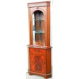 A freestanding mahogany finish corner cupboard.