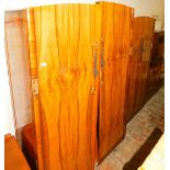 A walnut veneered bedroom suite, comprising two wardrobes and a dressing table.