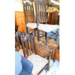 An oak drop leaf table and a set of oak Carolean style chairs with overstuffed seats.