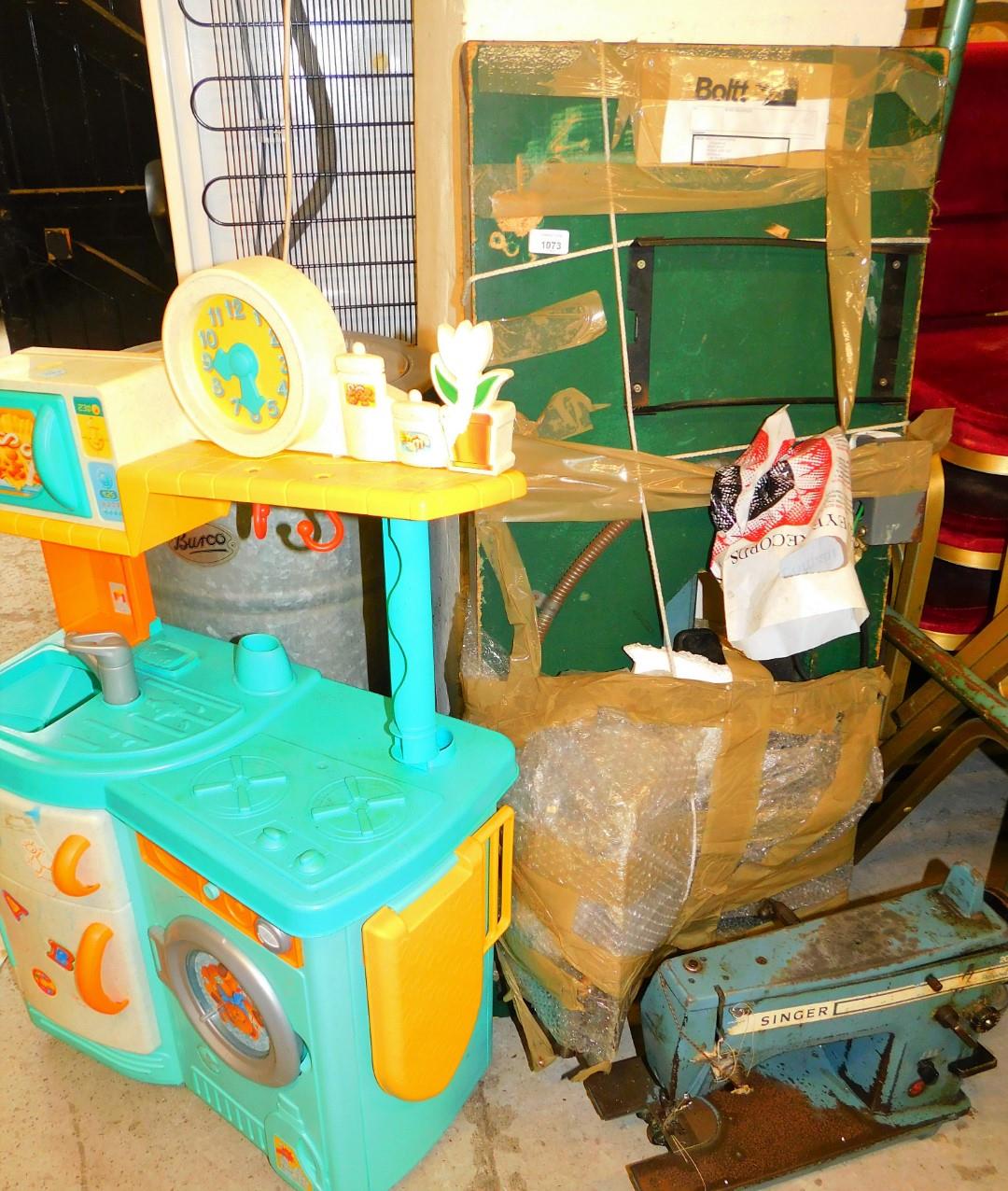 A Boltt sewing machine table with sewing machine and a child's plastic kitchen