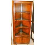 An Ercol style linen fold corner display cabinet, with drawers beneath.