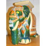 A pottery elephant vase stand in green.
