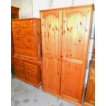A pine chest, of five long drawers, similar dressing table, two door wardrobe and a pedestal cabinet