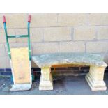 A reconstituted stone garden bench seat of shaped form and a sackbarrow.