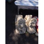 A pair of reconstituted stone garden lions, modelled in recumbent pose, 71cm W.