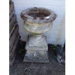 A reconstituted stoneware garden urn on a square plinth, 68cm H, 40cm Dia.