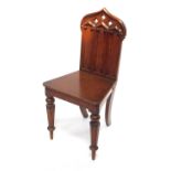 A Victorian gothic oak hall chair, the back with triple carved tracery and three pierce quatrefoils,