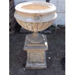 A Victorian Coade stone type urn on stand, the urn of semi fluted form, with four flowers to the