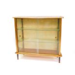 A vintage 1950's teak display cabinet, of trapezium form, with two glazed doors opening to reveal