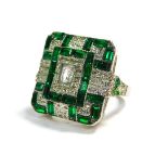 A modern Art Deco style dress ring, set with clear and green coloured paste, on a silver coloured