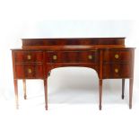 An Edwardian mahogany and crossbanded breakfront sideboard, with a panelled back, central fitted bow