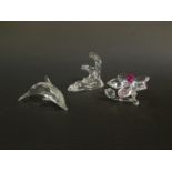 A Swarovski Crystal sculpture of a dolphin, modelled riding the crest of a wave, together with a