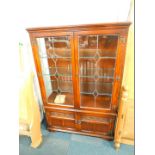 An Old Charm oak display cabinet, the outset pediment over two glazed doors opening to reveal