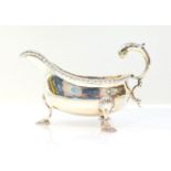 A Victorian silver sauce boat, with a gadrooned rim, double scroll handle, raised on three fluted