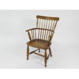 A 19thC oak and elm comb back Windsor chair, possibly West Country, with solid saddle seat, raised