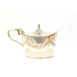 A Victorian silver mustard pot, with a hinged lid of semi-fluted bucket form, engraved with swags,