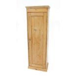 A slender pine cupboard, with moulded top, enclosed by a single panel door, and fitted with three