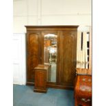 A Victorian oak compactum wardrobe, the outset pediment over a central door, inset domed bevelled