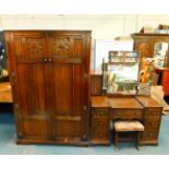 A Tudor style oak double wardrobe, with linenfold and Gothic arch tracery panelled doors, opening to